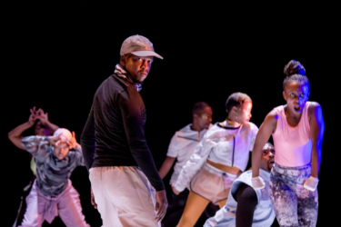 A group of five dancers from Via Katlehong dance company performing on stage.