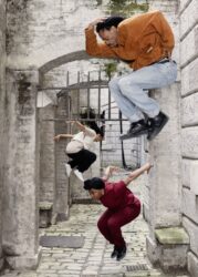 Evion Hackett, Angelica Brewster and Jade Hackett jumping in front of stone arches at Somerset House.