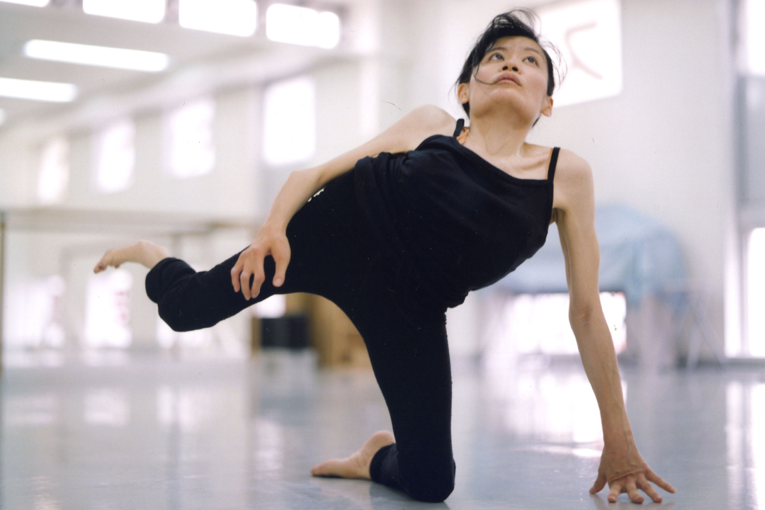 Image of Kazuyo Morita wearing all black, posing in a dance studio.